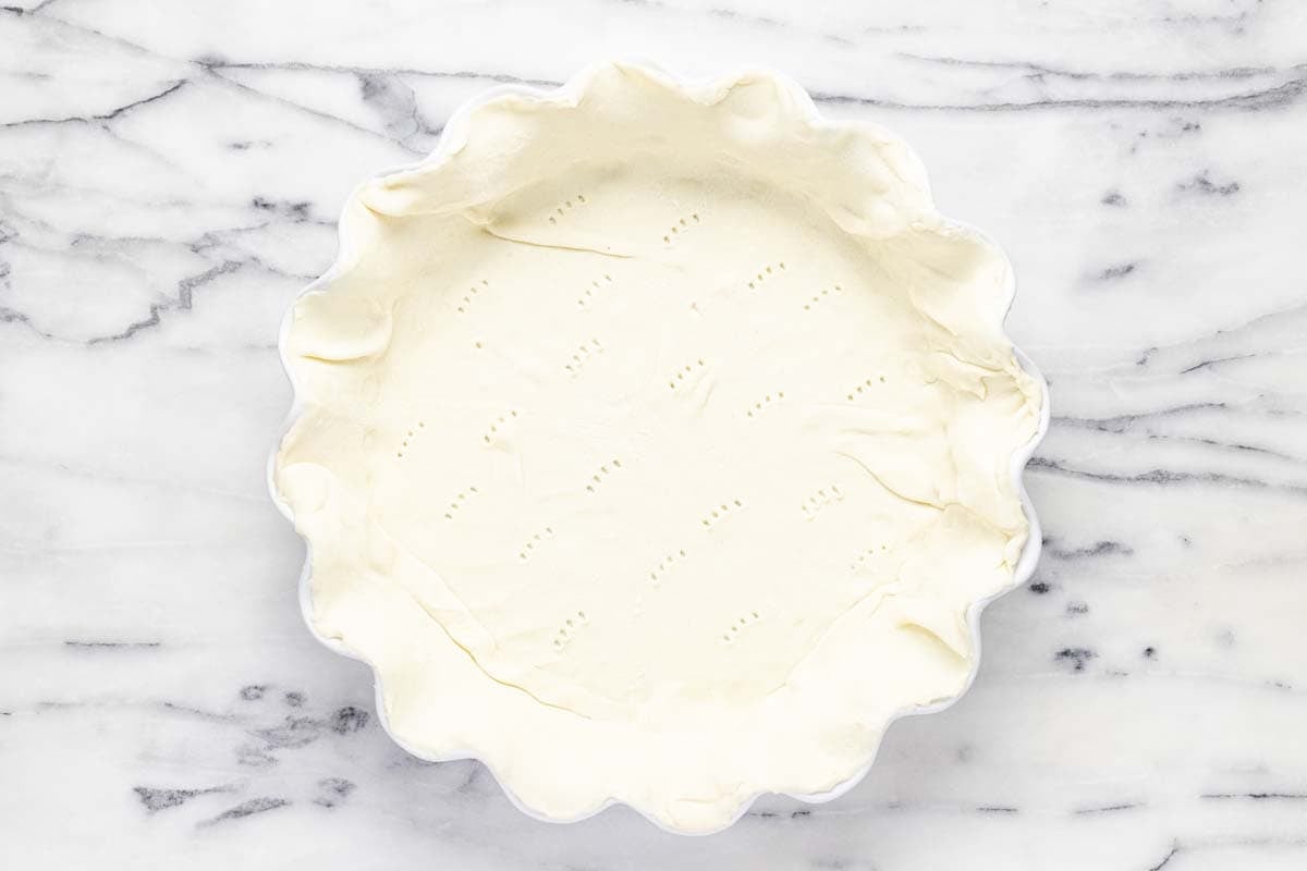 Puff pastry dough in the bottom of a pie pan. 