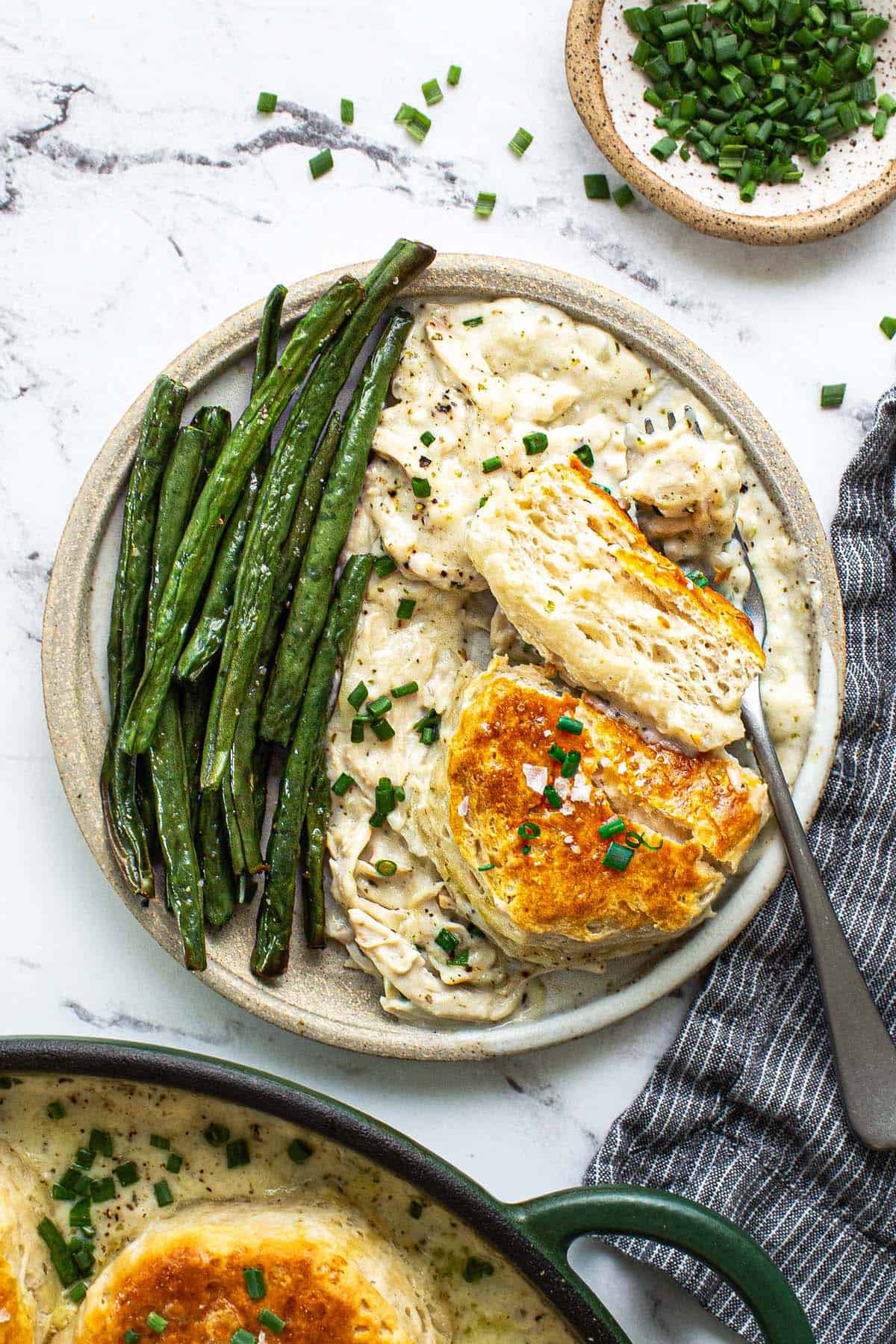 Plate of creamy chicken and biscuits with green beans. 