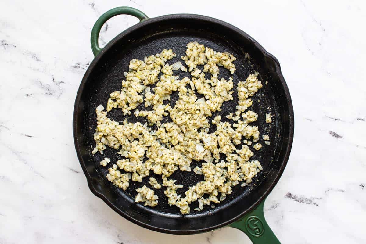 Large pan with sauteed herbs and onions. 