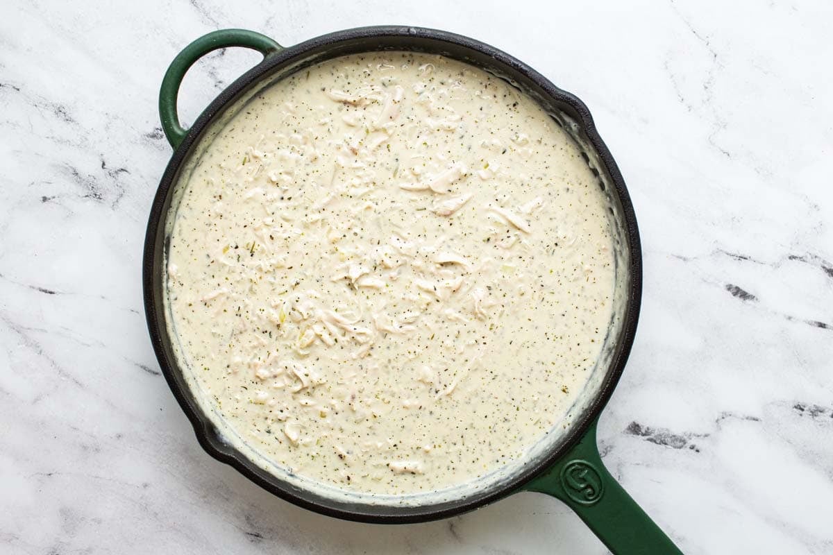 Large pan filled with creamy chicken in gravy. 