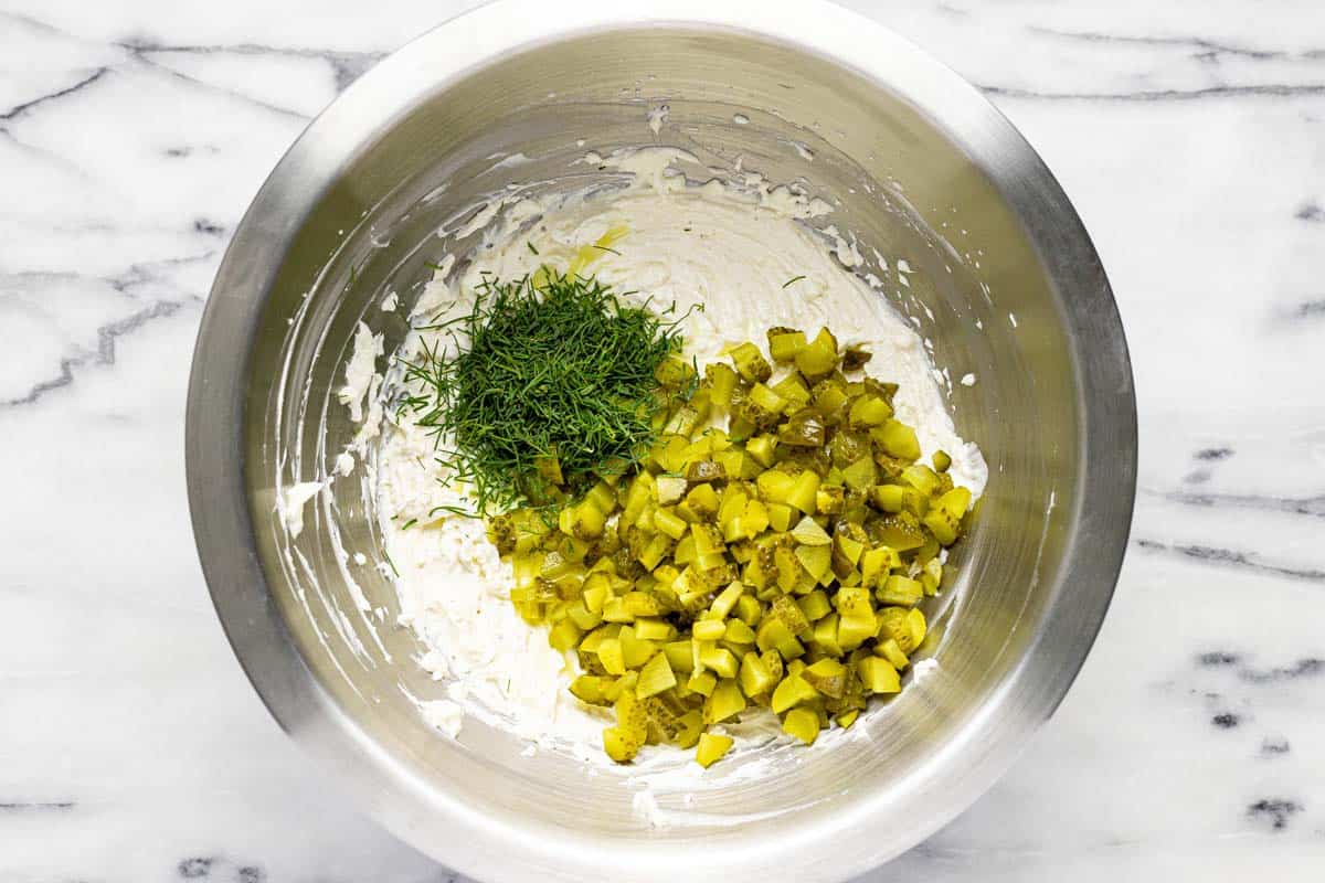 Diced pickles and dill in a cream base for dill pickle dip. 