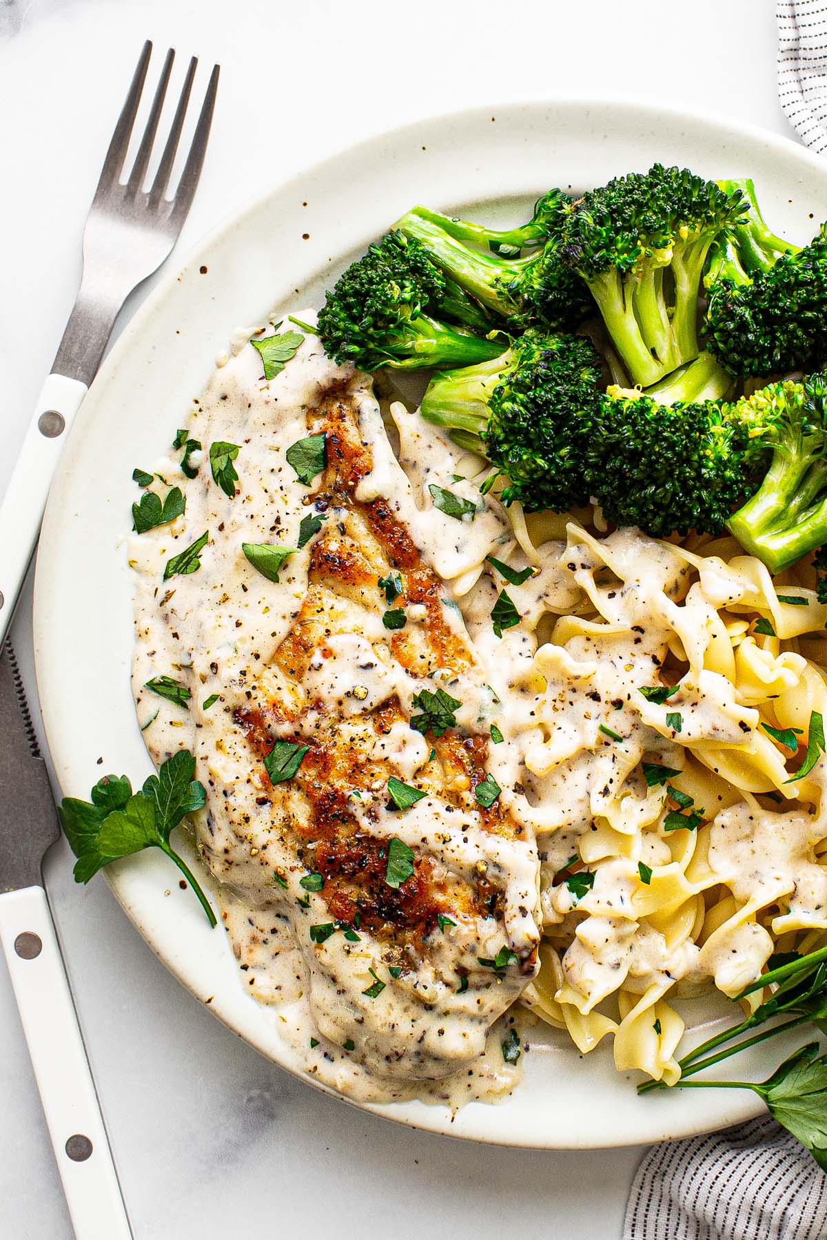 Plate with garlic Parmesan chicken, pasta, and broccoli. 