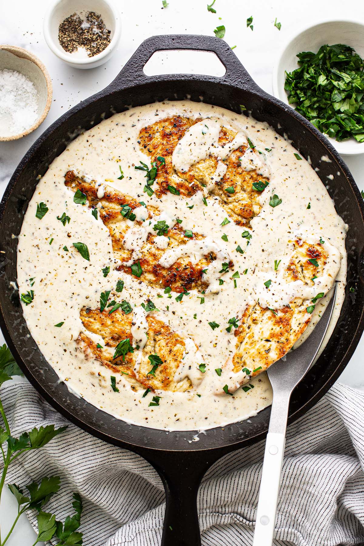 Skillet with creamy garlic Parmesan chicken in a sauce. 