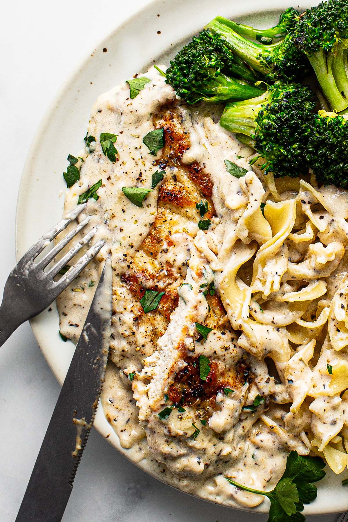 Plate with garlic Parmesan chicken, pasta, and broccoli. 