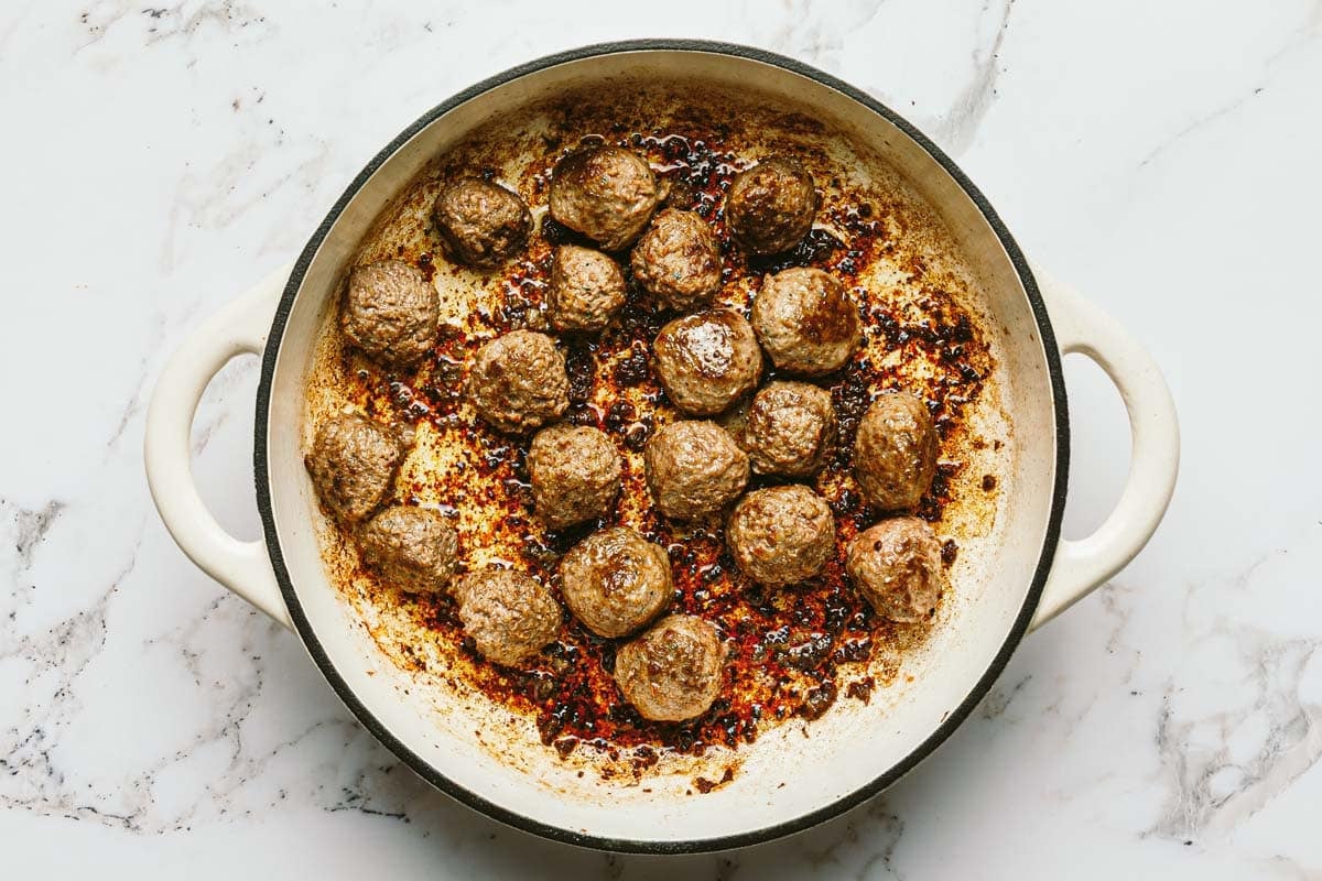 Sauteed meatballs in a large pan. 