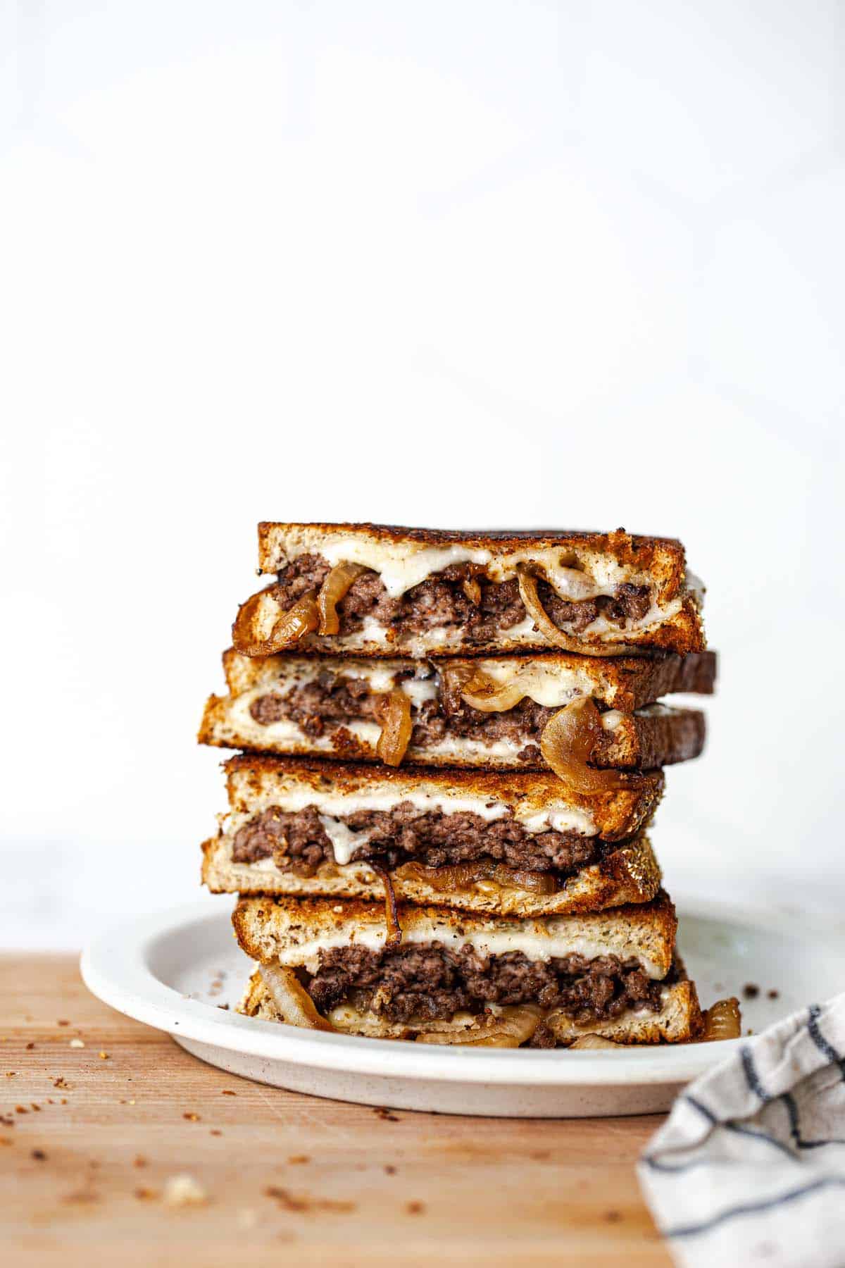 Halved patty melts on a plate.