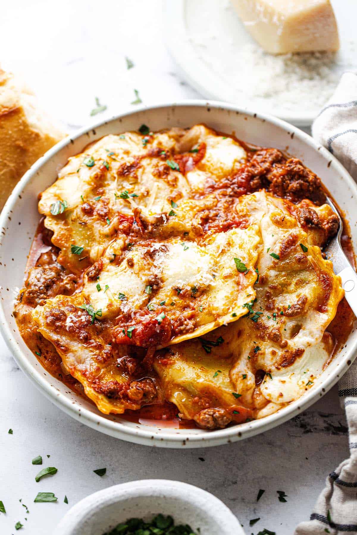 Cheesy ravioli and meat sauce in a bowl. 