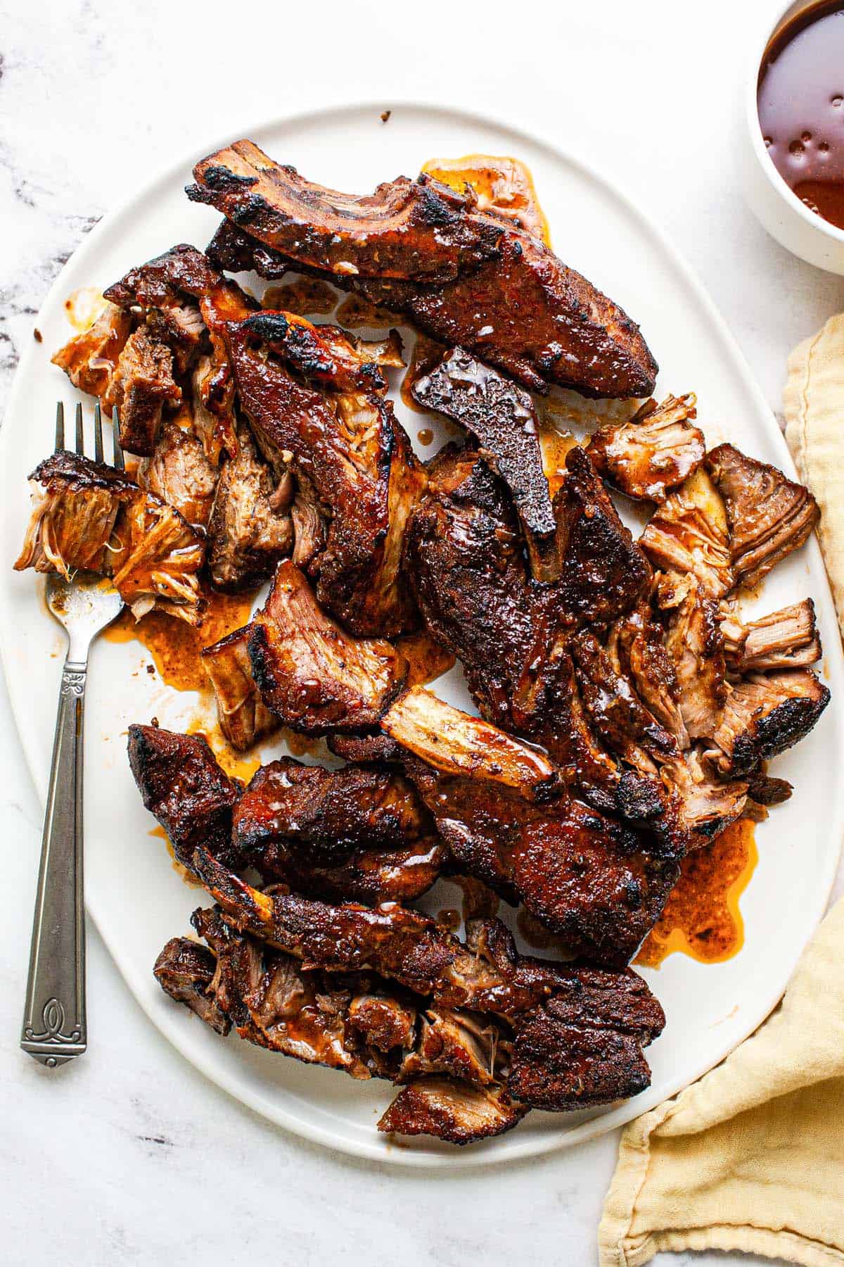Large serving platter with shredded country style ribs in barbecue sauce. 
