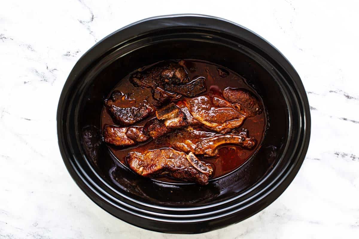 Cooked ribs in a delicious sauce in a crockpot. 