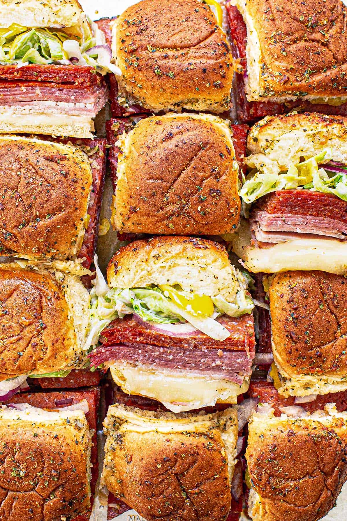 Close up of Italian sliders sliced apart with a few on their sides.