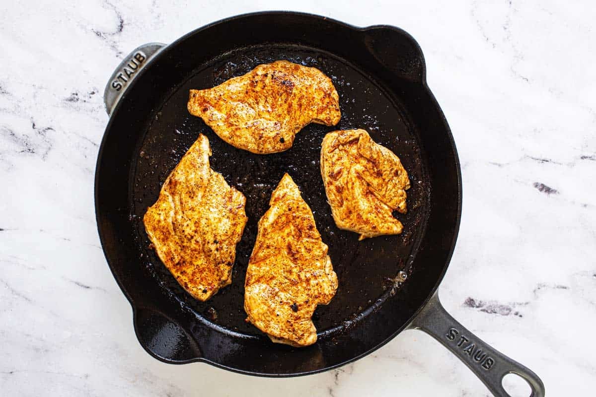 Chicken breast seared in bacon grease in a large cast iron pan. 