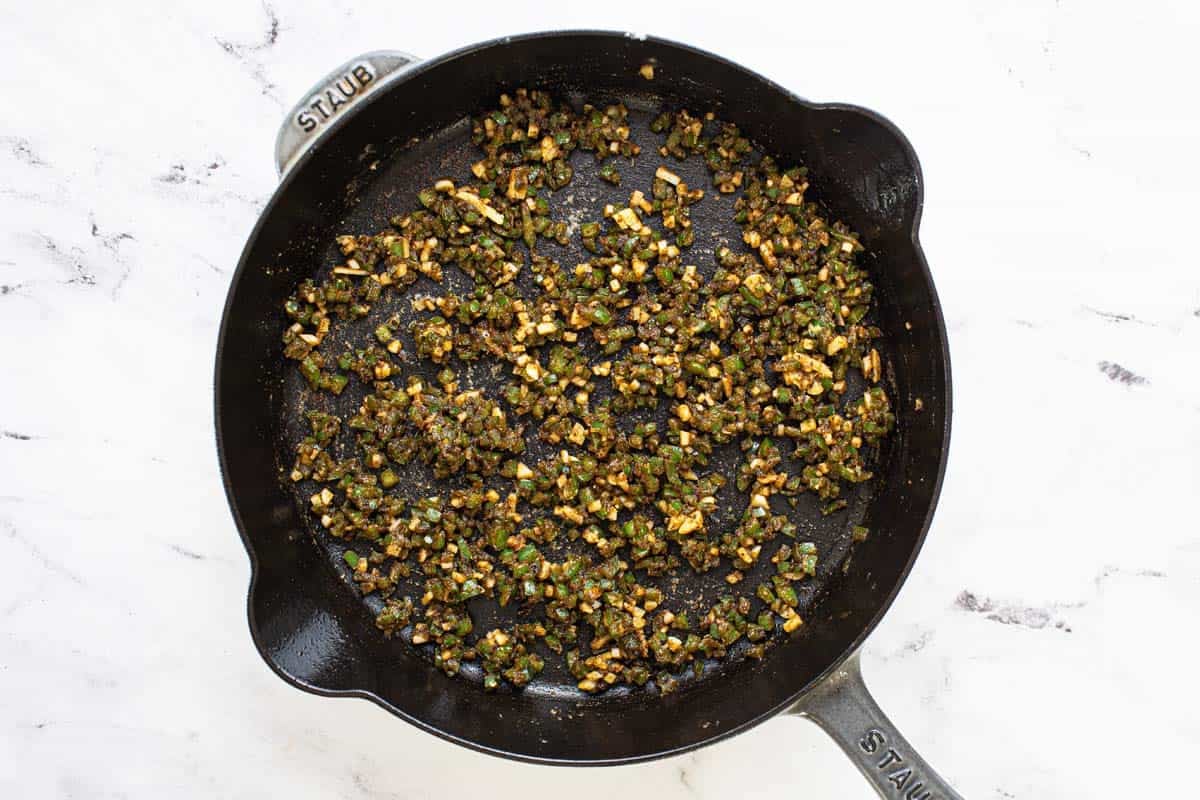 Sauteed jalapeno and garlic in a large cast iron pan. 