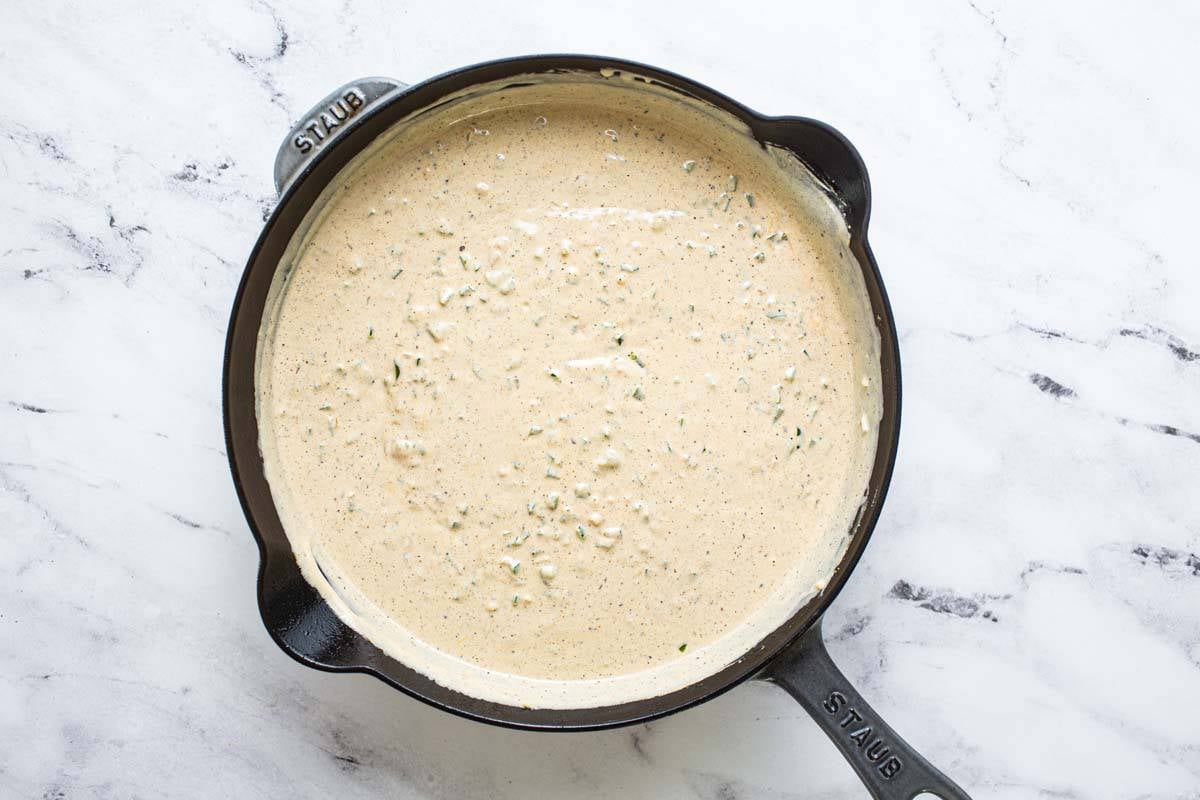 Large cast iron pan filled with creamy jalapeno sauce. 