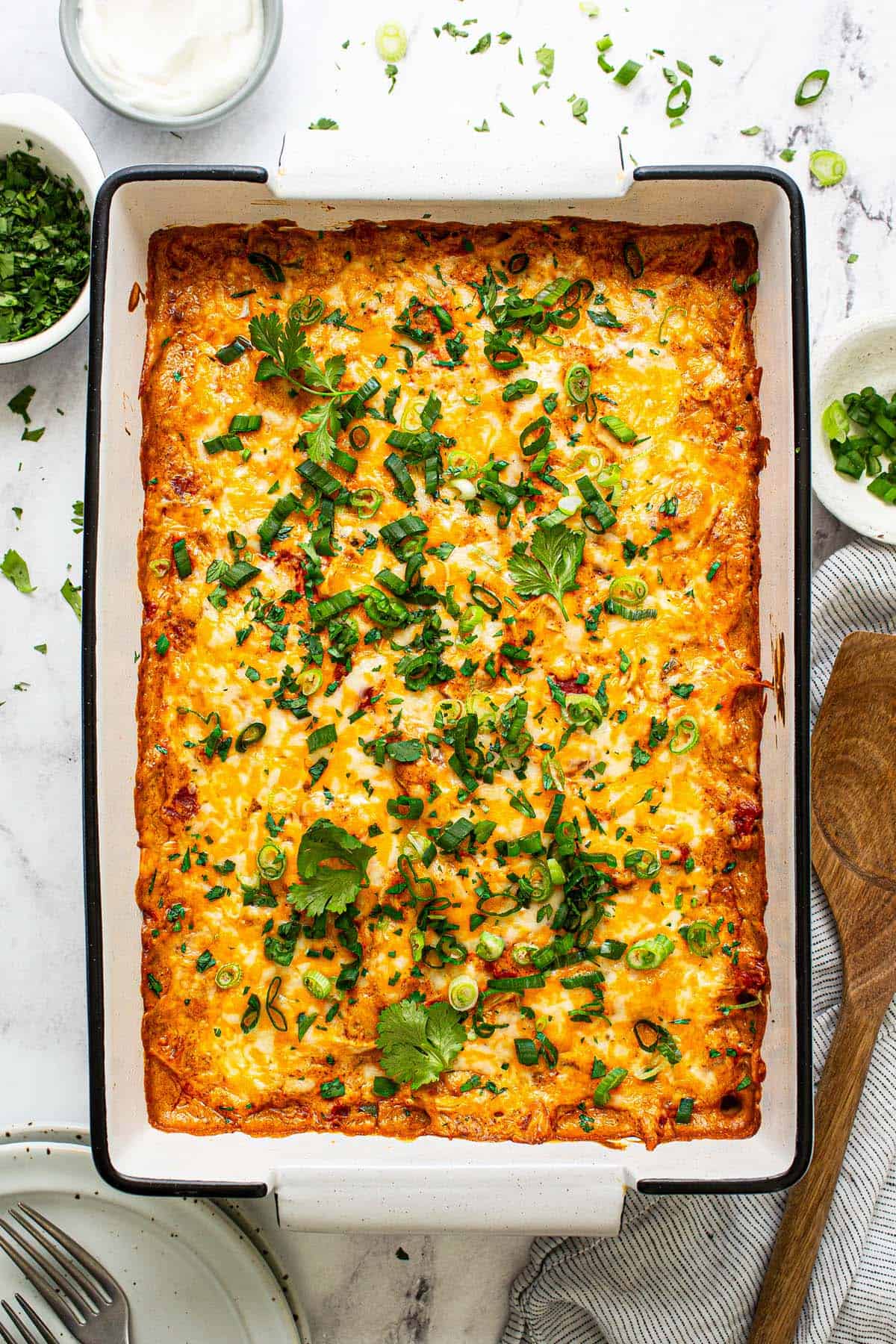 Large baking dish filled with king ranch chicken casserole garnished with green onion and cilantro. 