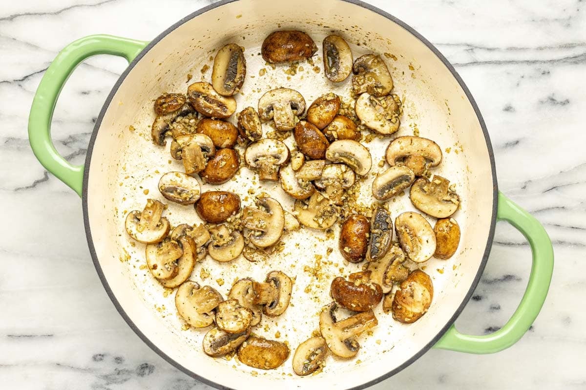 Pan filled with sliced mushrooms and garlic. 