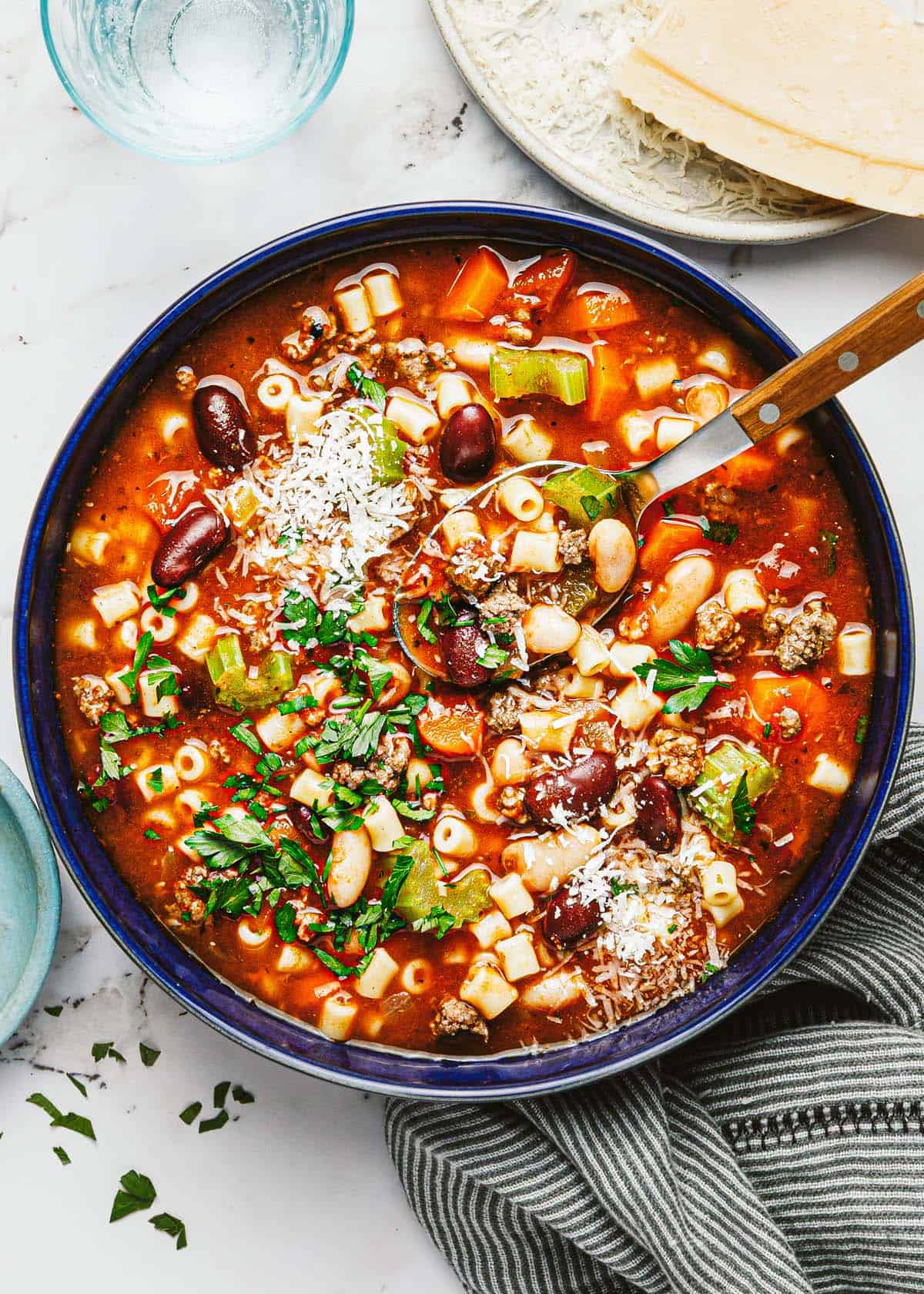 Large bowl filled with pasta fagioli soup garnished with Parmesan. 