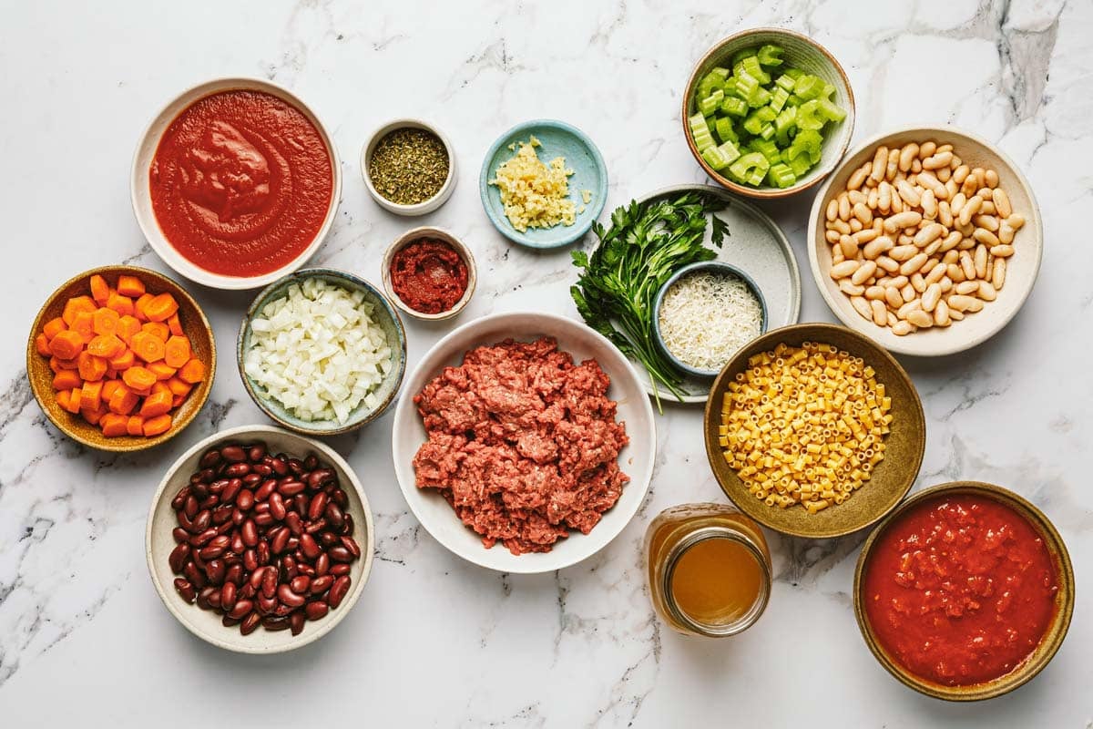 Bowls of ingredients to make Italian pasta fagioli. 