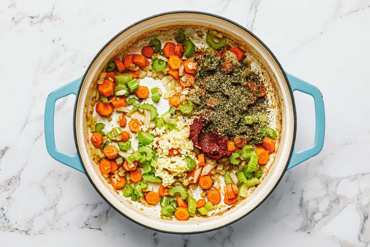 Large pot filled with sauteed veggies, garlic, tomato paste, and herbs. 