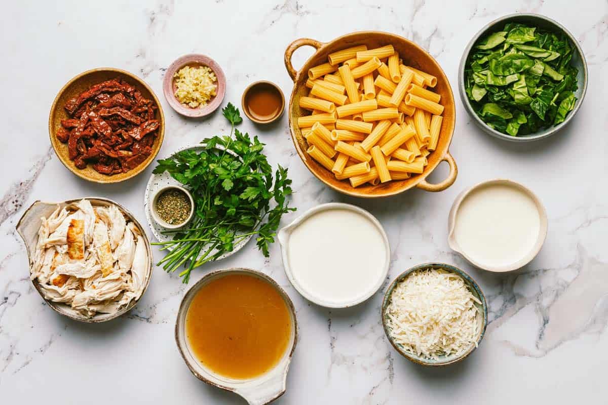 Bowls of ingredients to make Tuscan chicken pasta. 