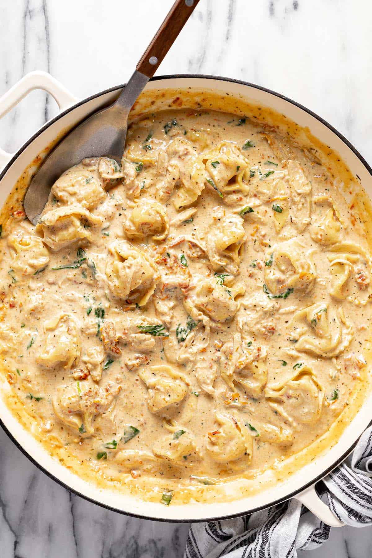 Large pan of creamy Tuscan tortellini pasta. 