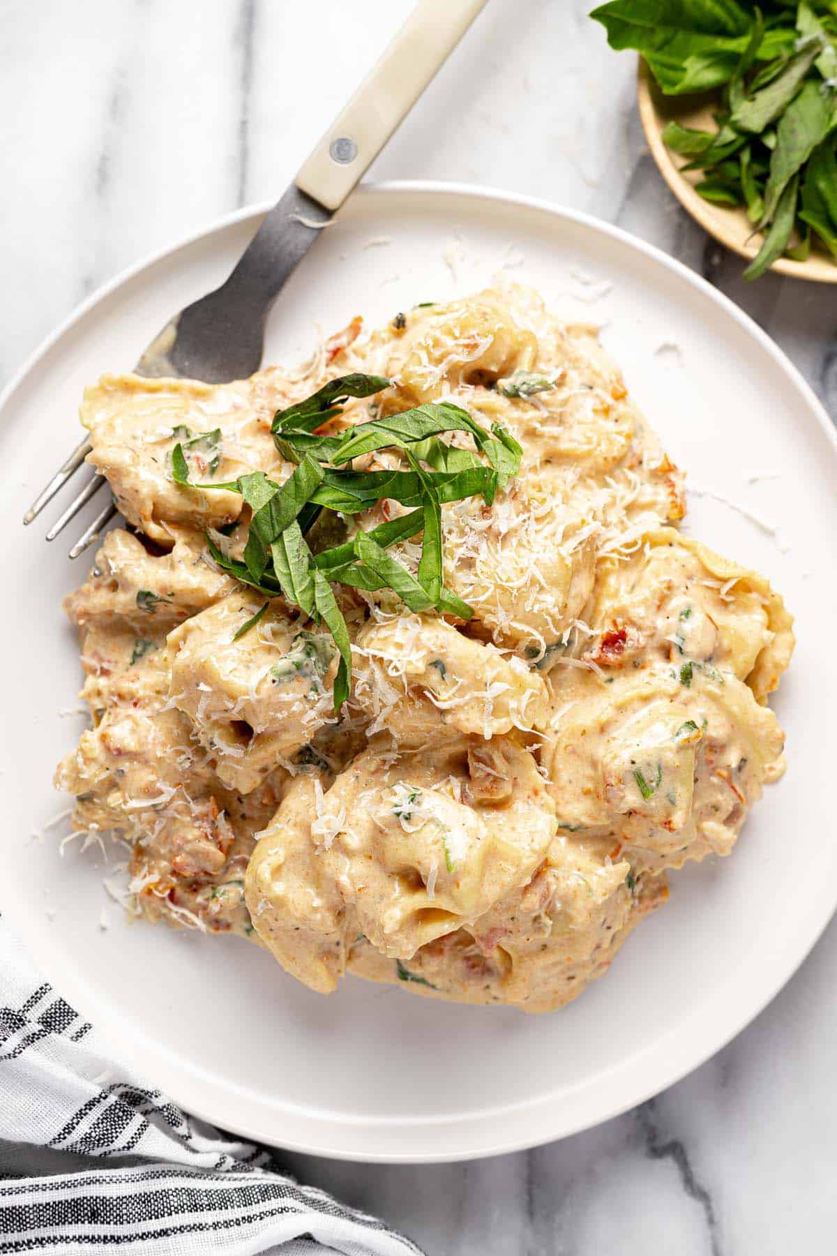 Plate filled with creamy Tuscan chicken tortellini. 