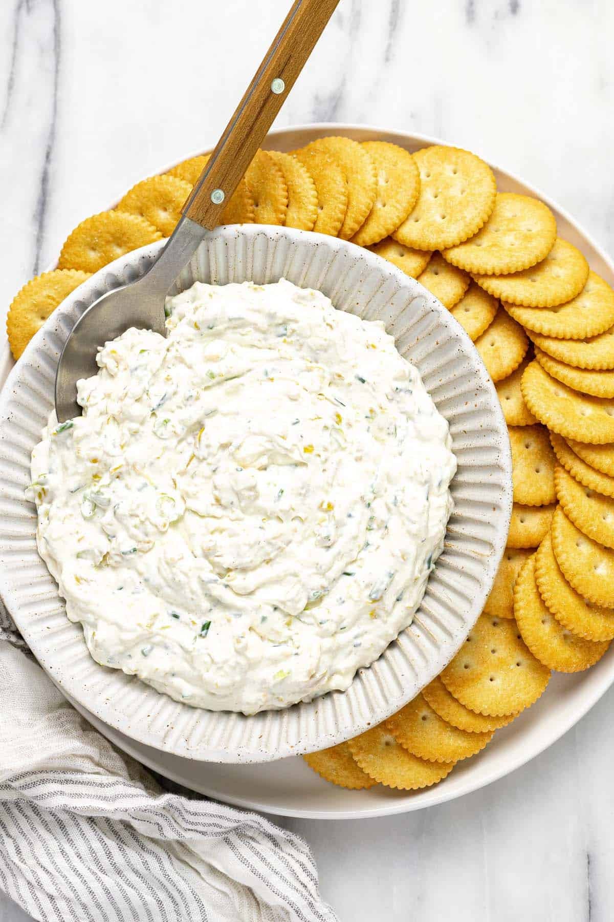 Bowl of pepperoncini dip on a plate of Ritz crackers. 
