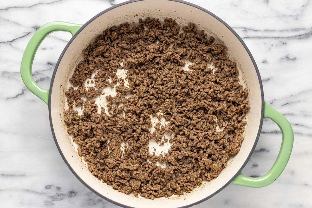 Large pan with browned ground beef and seasonings. 