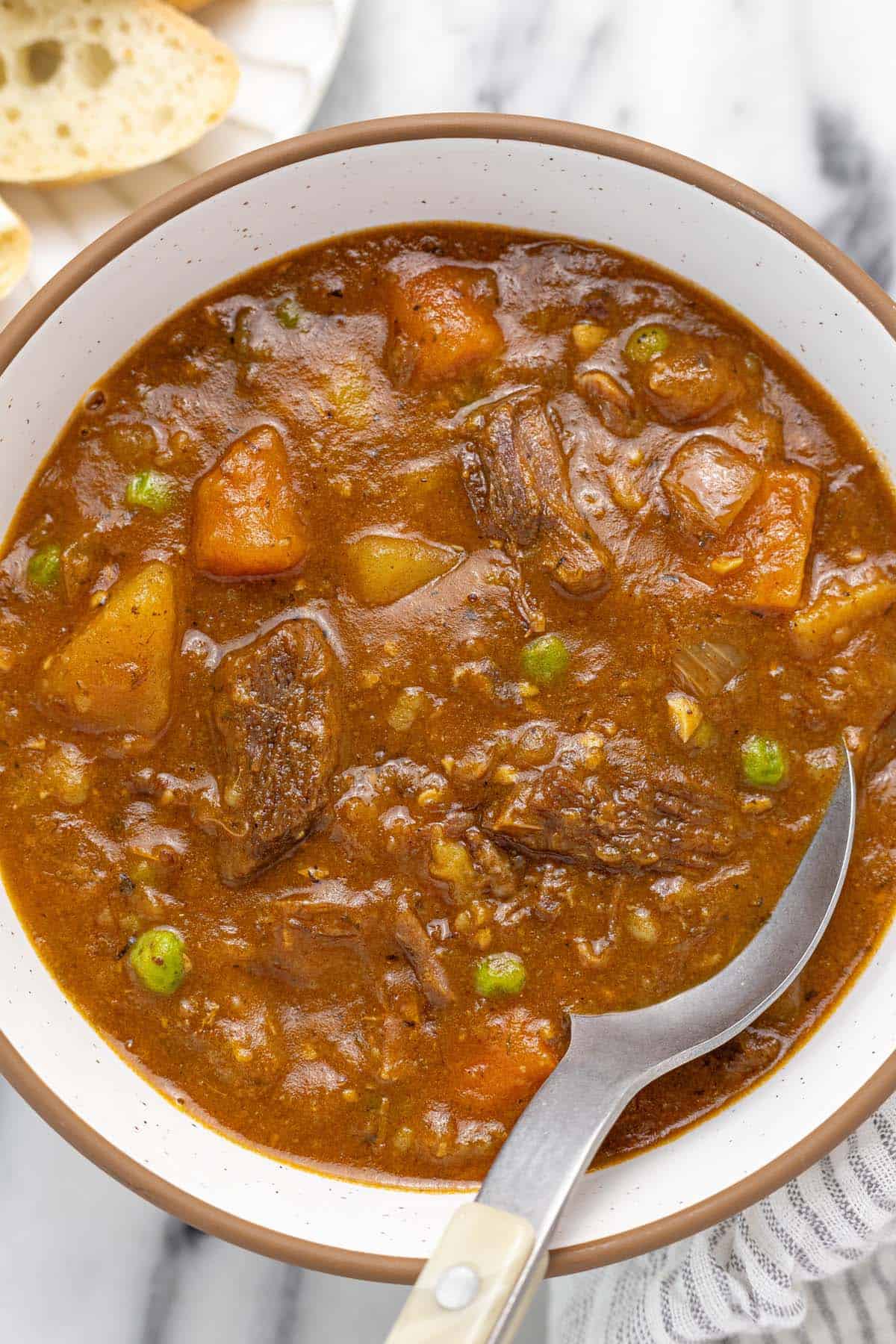 Bowl of instant pot beef stew with a spoon.