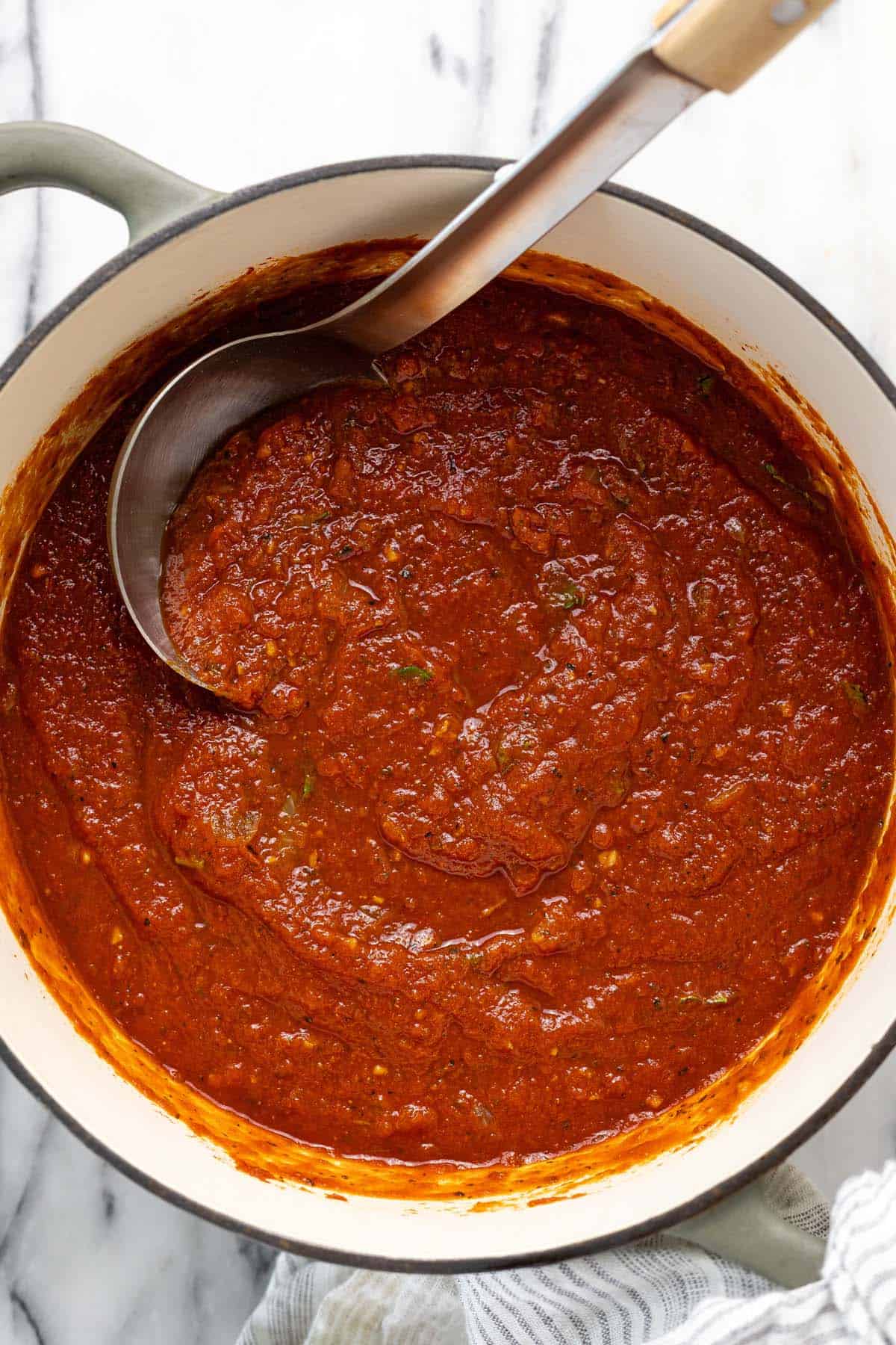 Large pot of homemade pasta sauce with a ladle. 