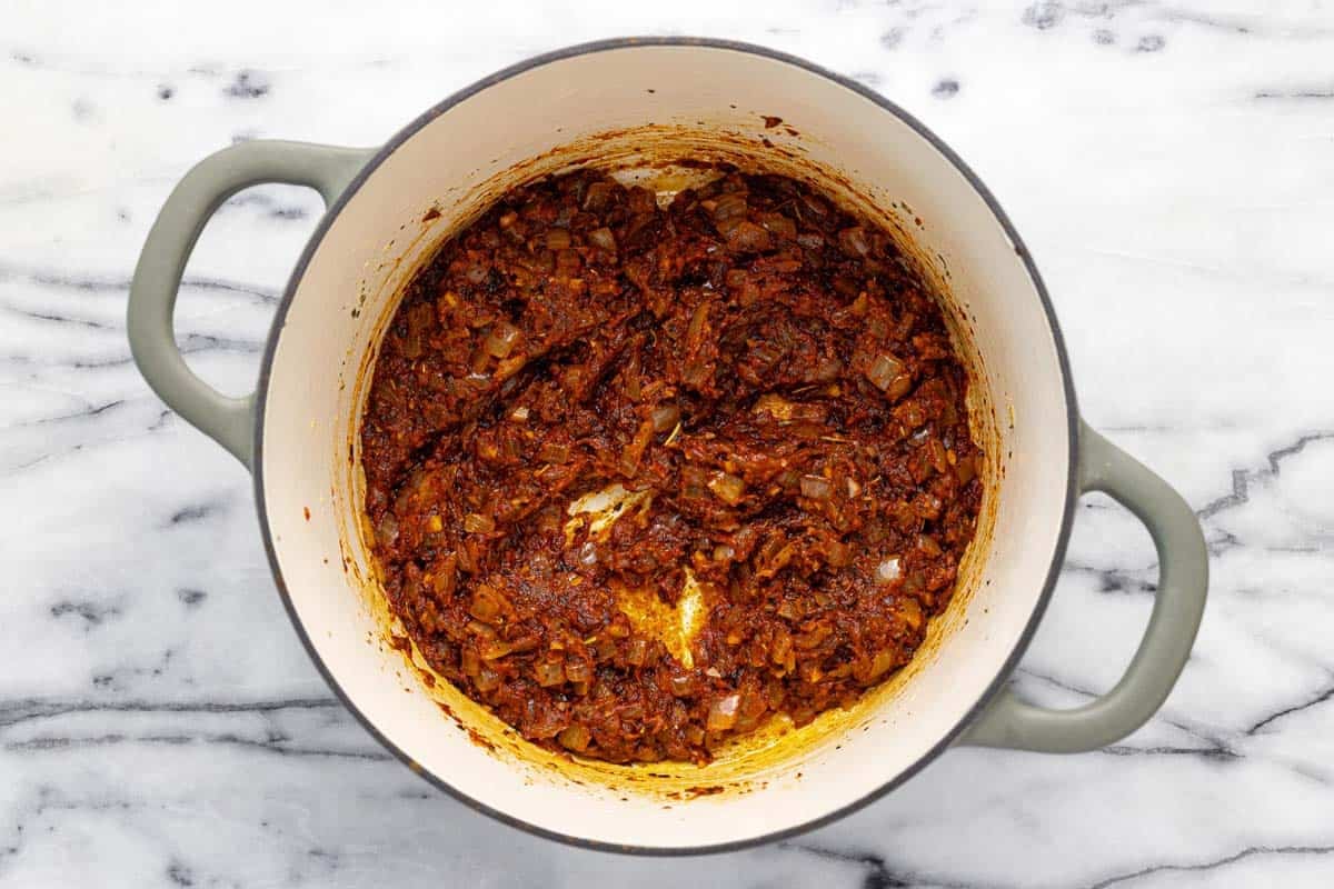 Large pot filled with tomato paste and sauteed veggies. 