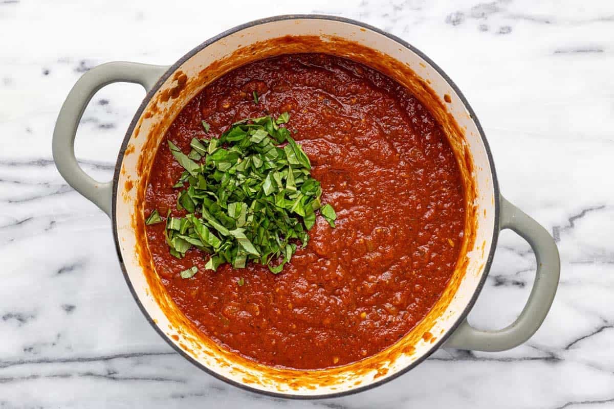 Large pot of spaghetti sauce with fresh chopped basil added. 