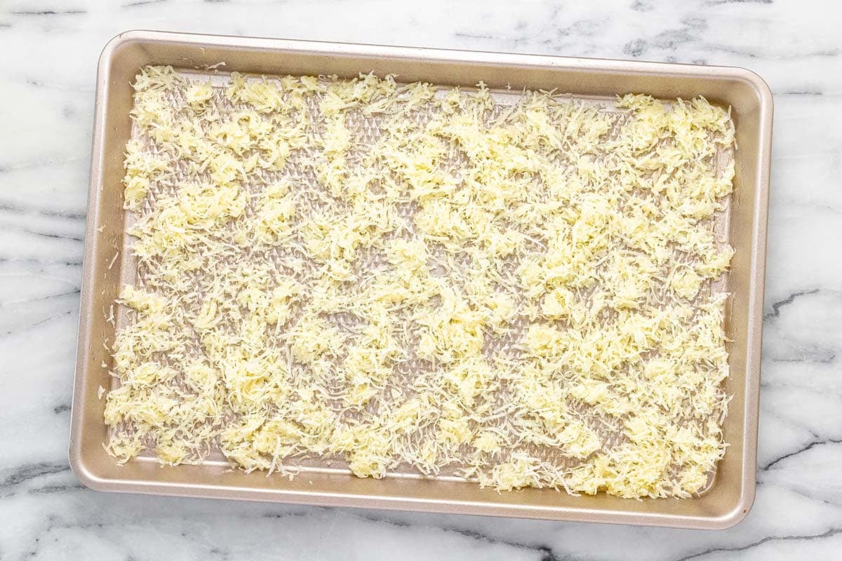 Baking sheet with Parmesan and butter spread across it. 