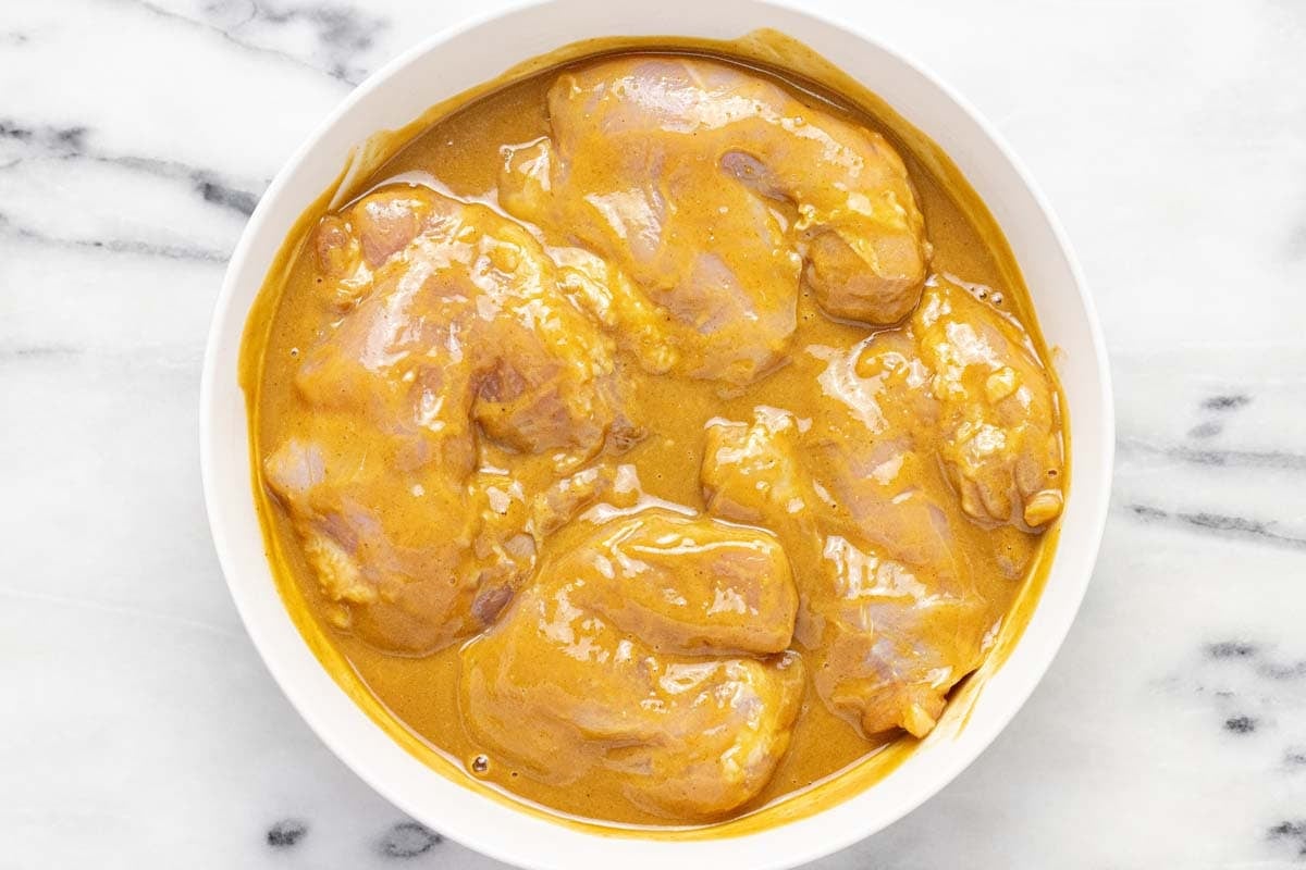 Chicken thighs marinating in creamy peanut sauce. 