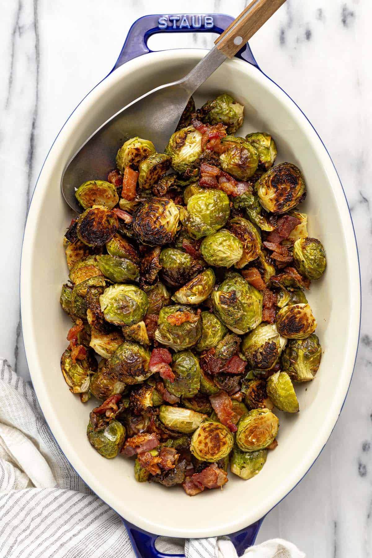 Baking dish filled with roasted Brussels sprouts and bacon.