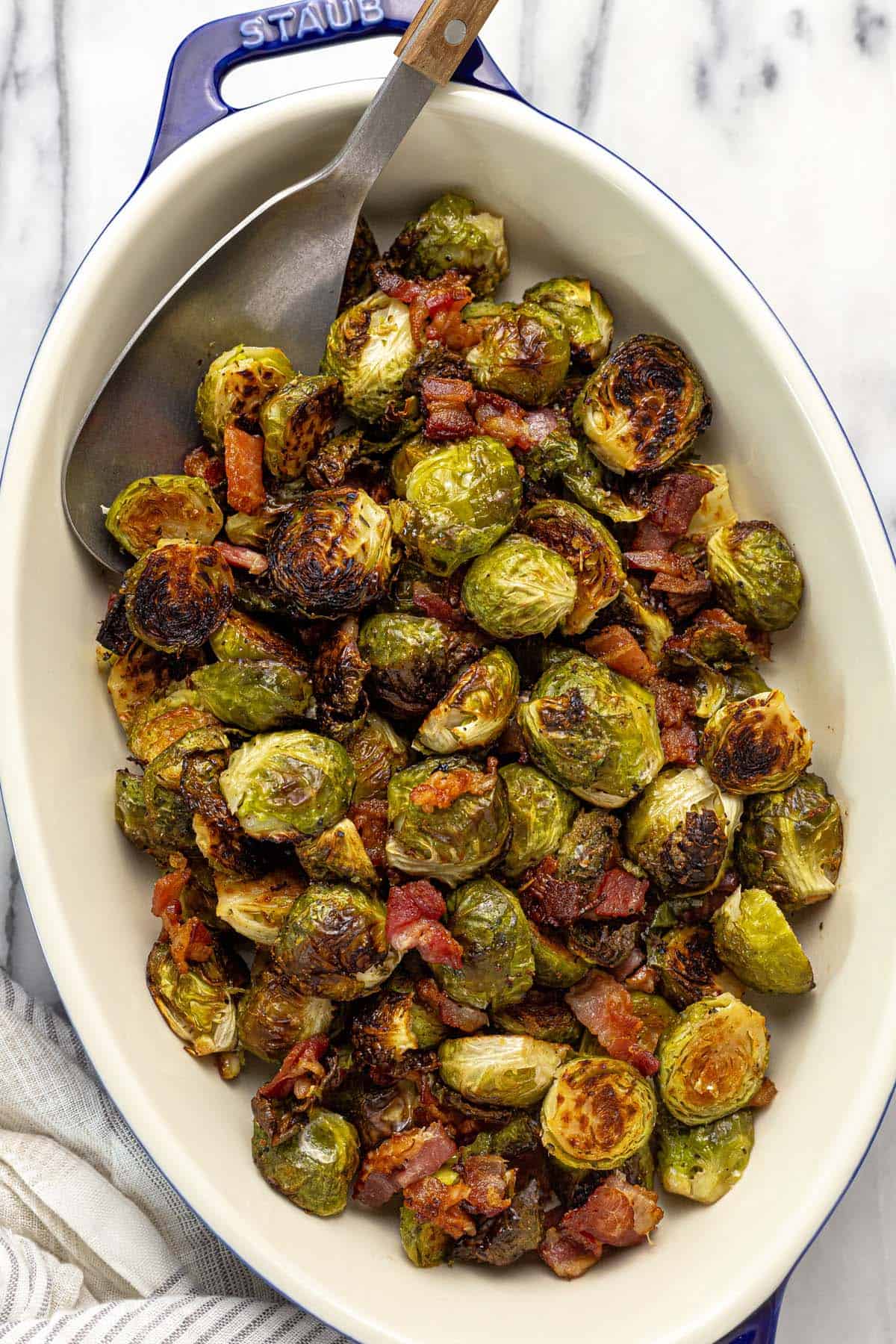 Baking dish filled with roasted Brussels sprouts and bacon.