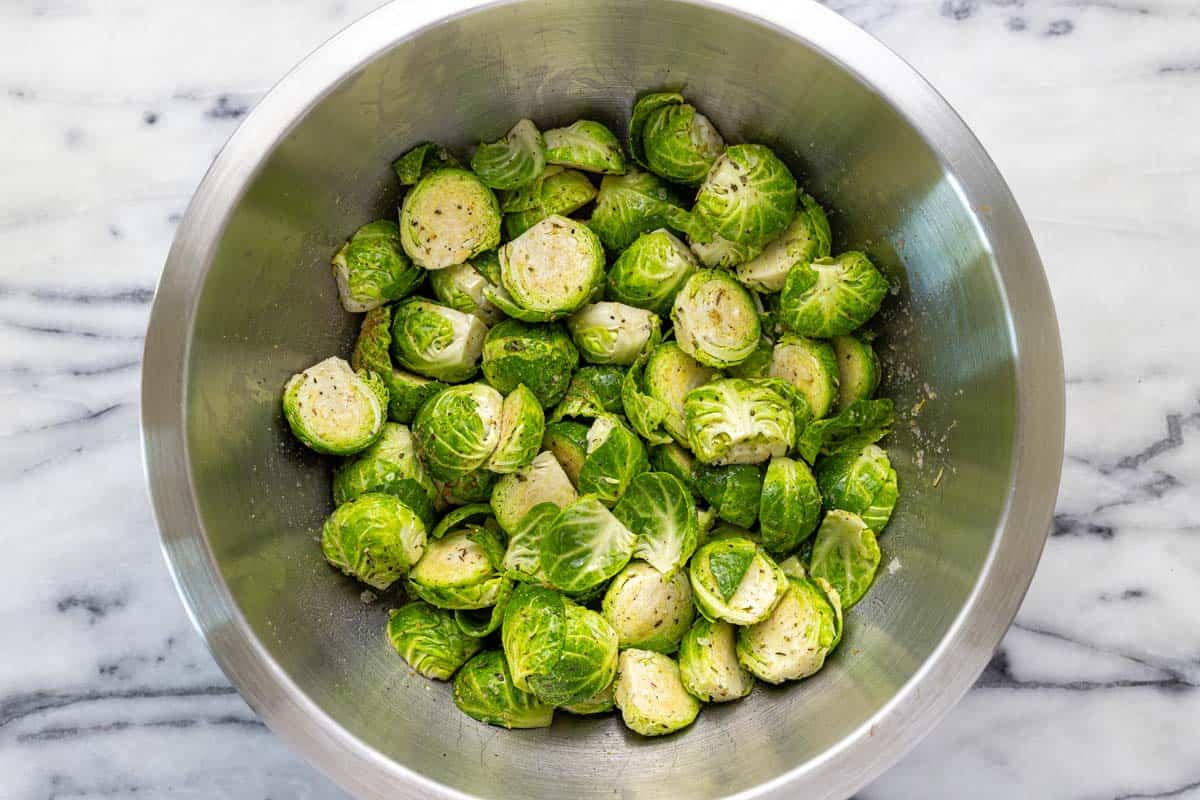 Bowl of Brussels sprouts tossed in herbs and spices.