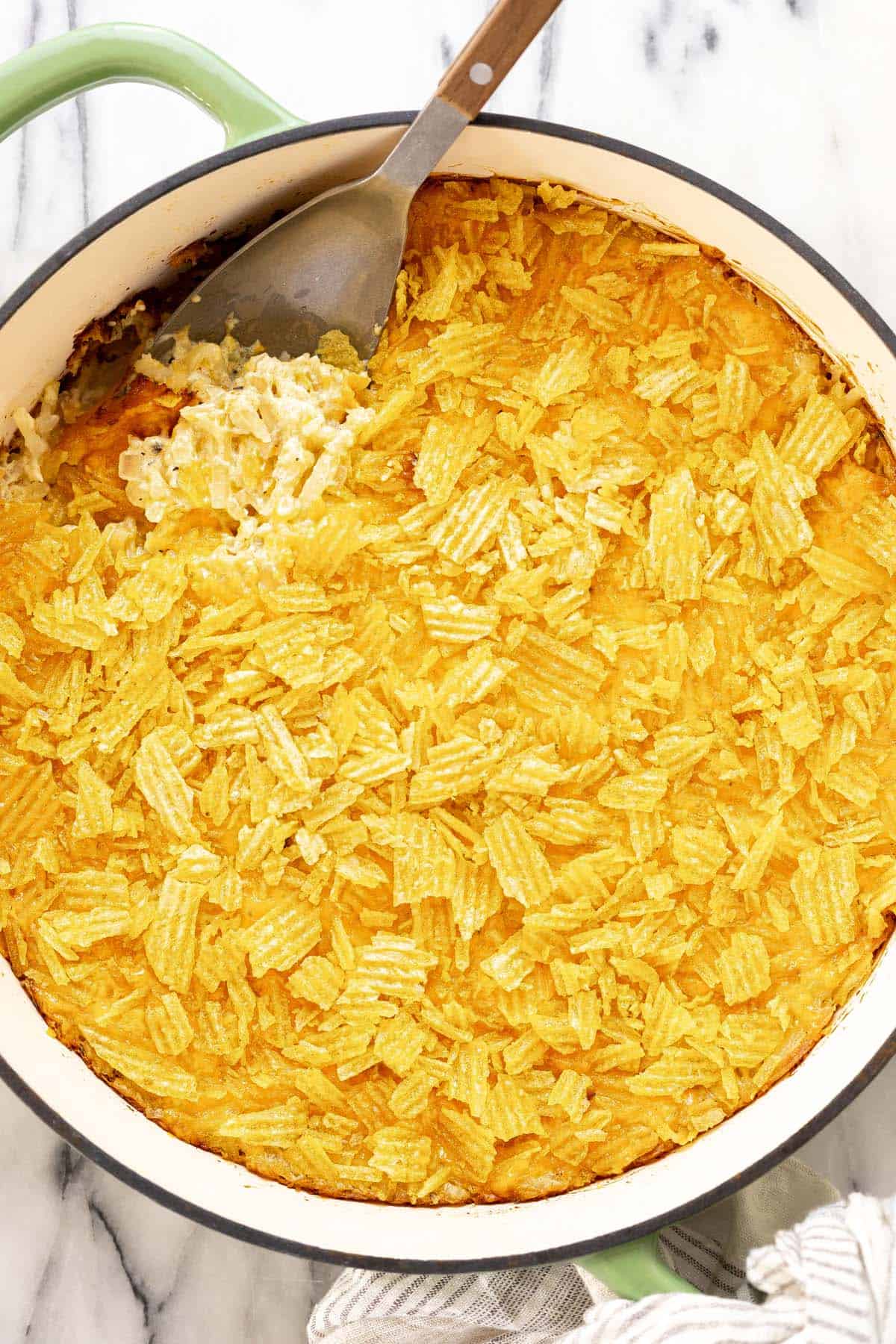Large pan filled with homemade cheesy hashbrown casserole. 
