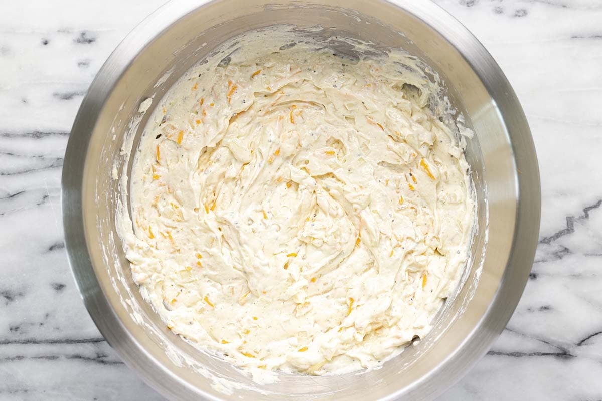 Large bowl filled with cheesy hashbrown sauce. 