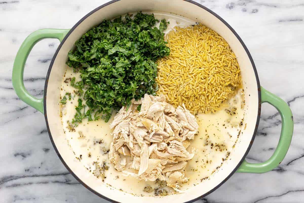 Broth, half and half, kale, chicken, and orzo added to a large pan. 