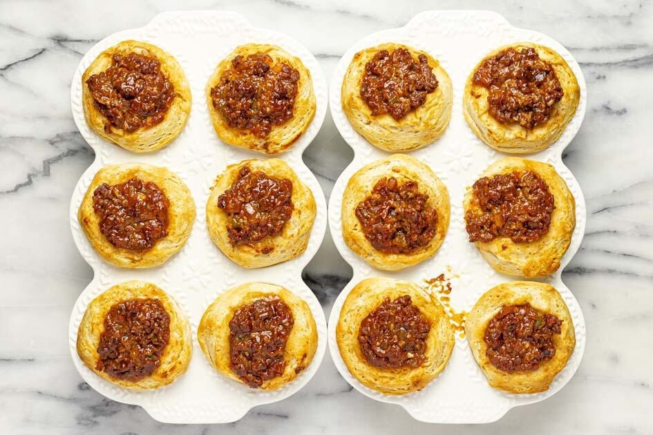 Two muffin tins with freshly baked sloppy joe biscuits. 