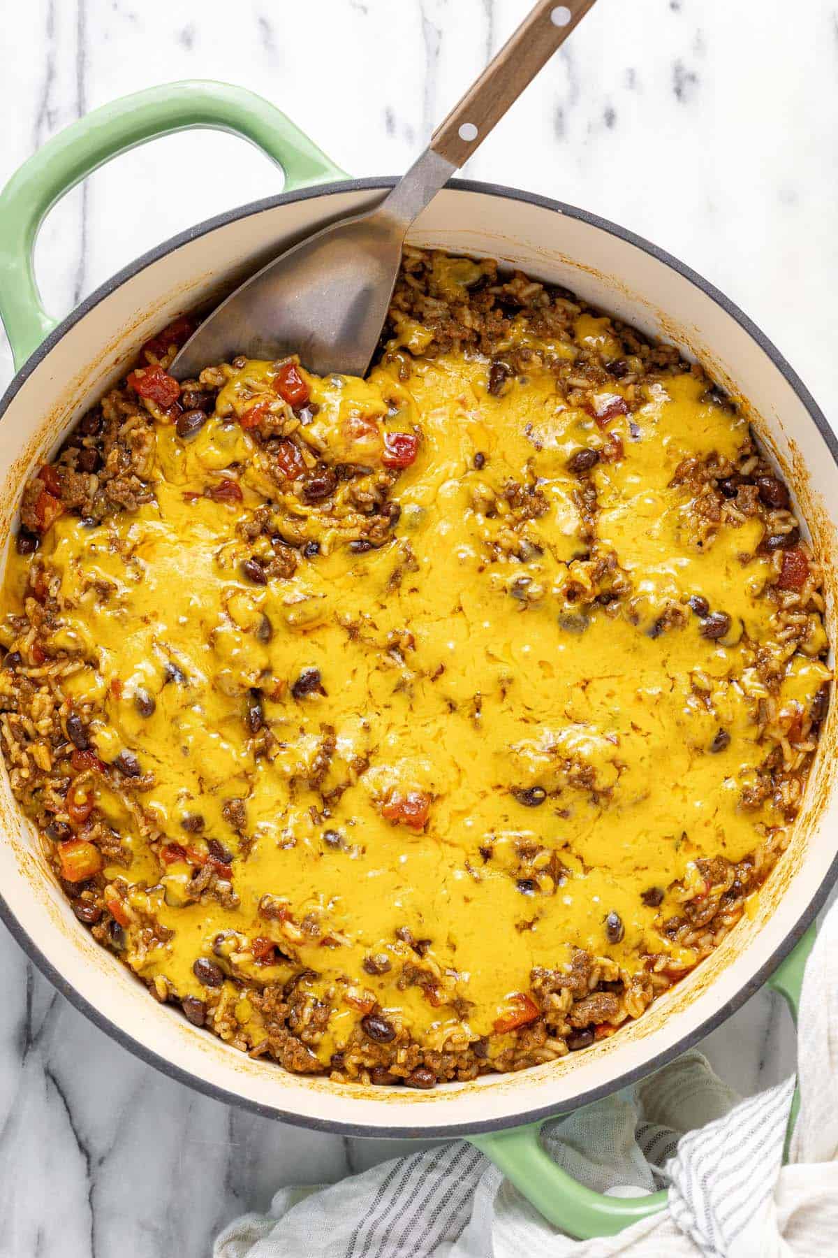 Large pan filled with cheesy ground beef taco rice.
