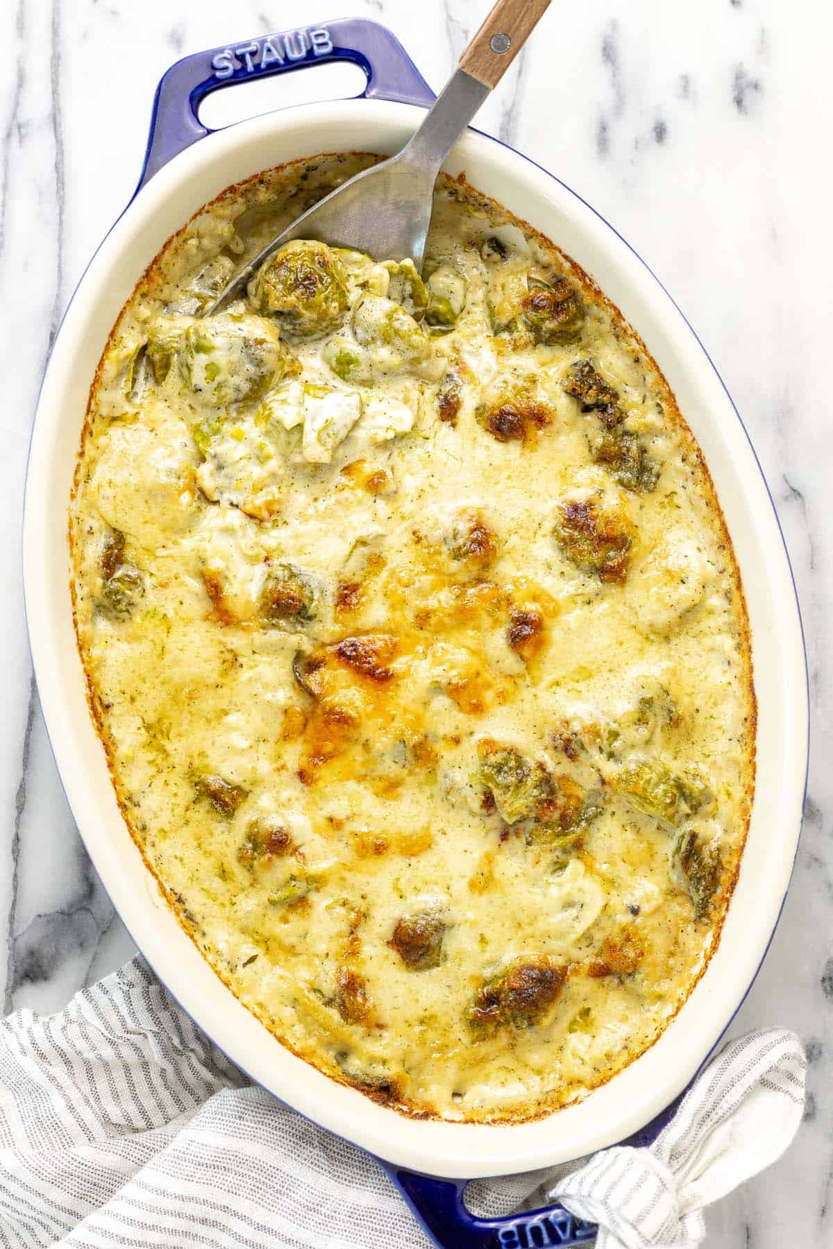 Baking dish filled with cheesy Brussels sprouts au gratin. 