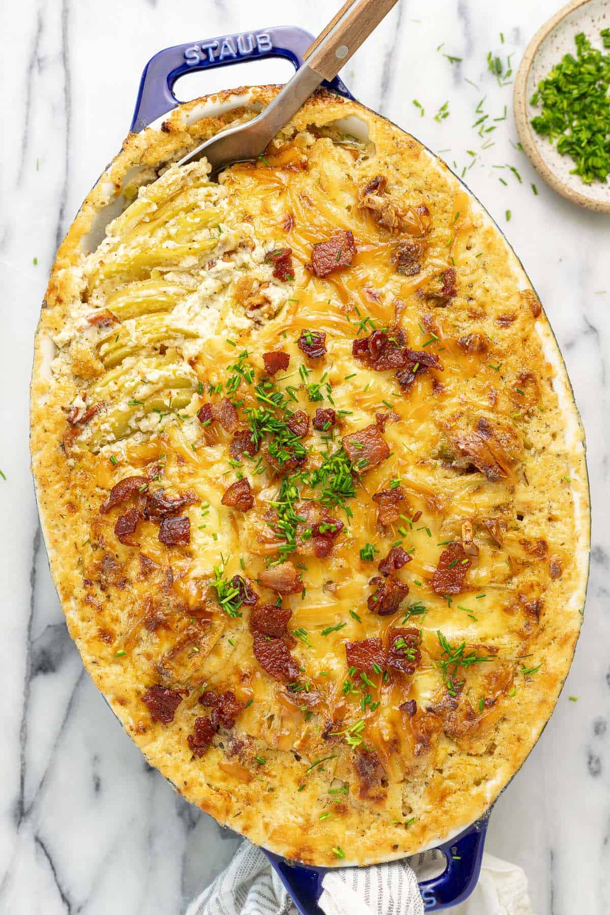 Baking dish filled with au gratin potatoes with leeks and bacon. 