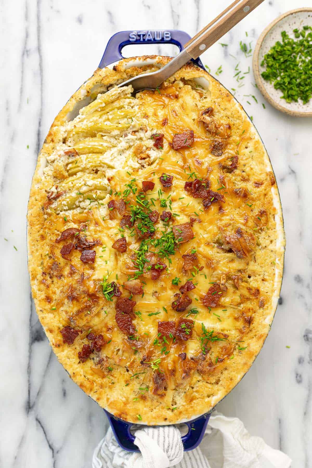 Baking dish filled with au gratin potatoes with leeks and bacon. 