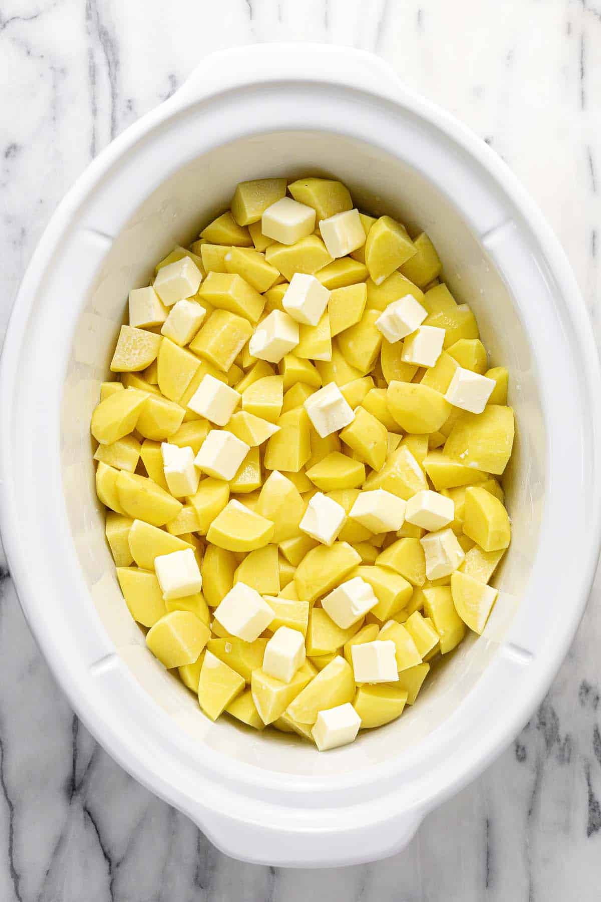 Diced potatoes and butter with broth and cream in a large crock pot. 