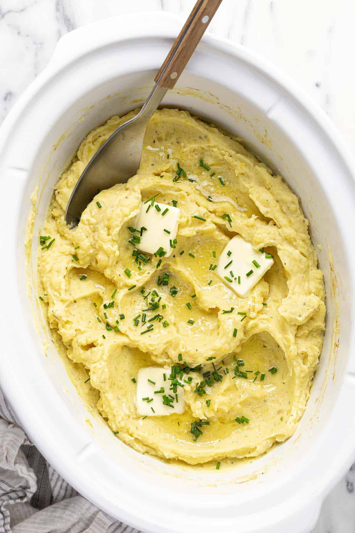 Crock pot insert filled with creamy homemade mashed potatoes. 