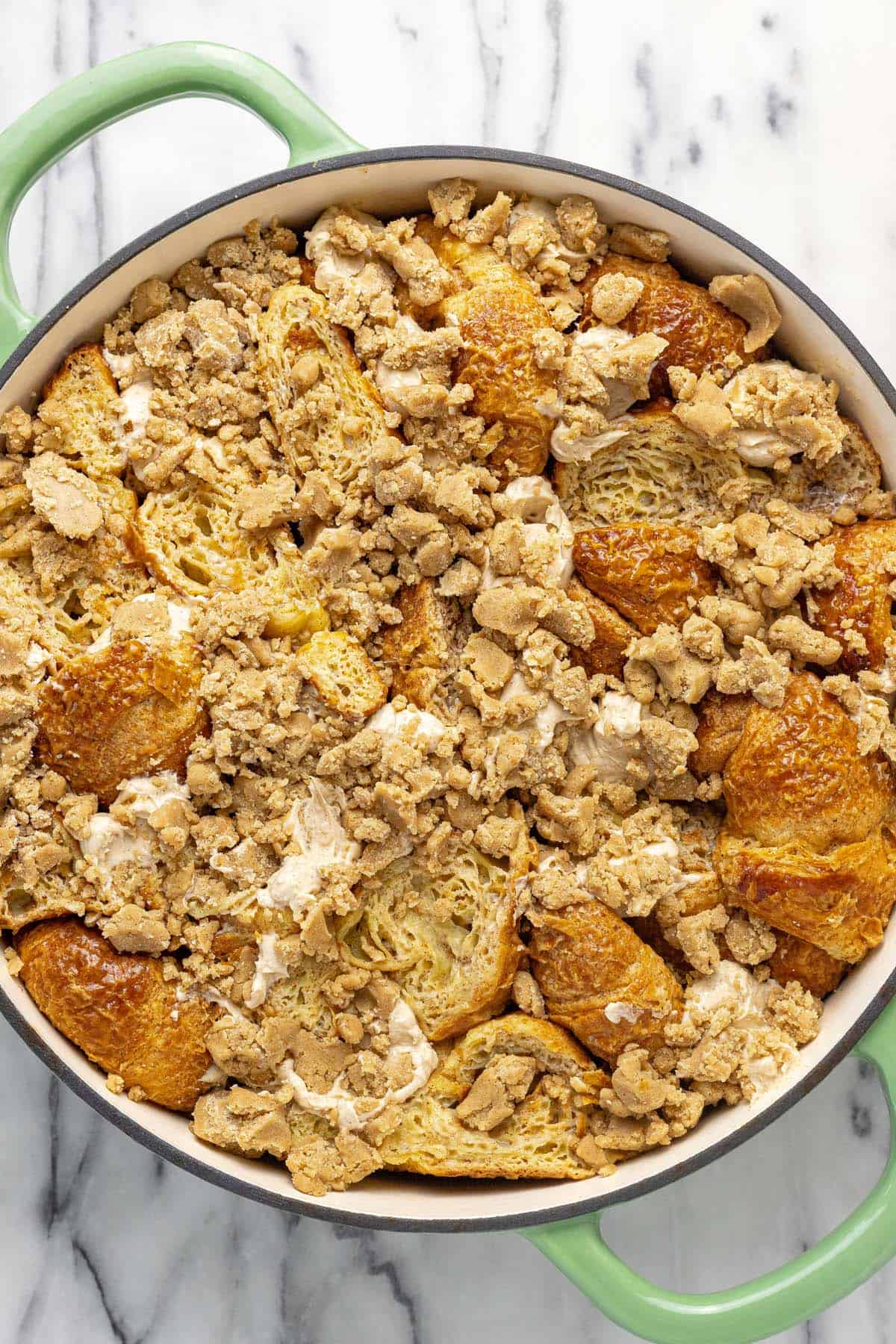 Crumble topping added to a pan of croissant French toast.