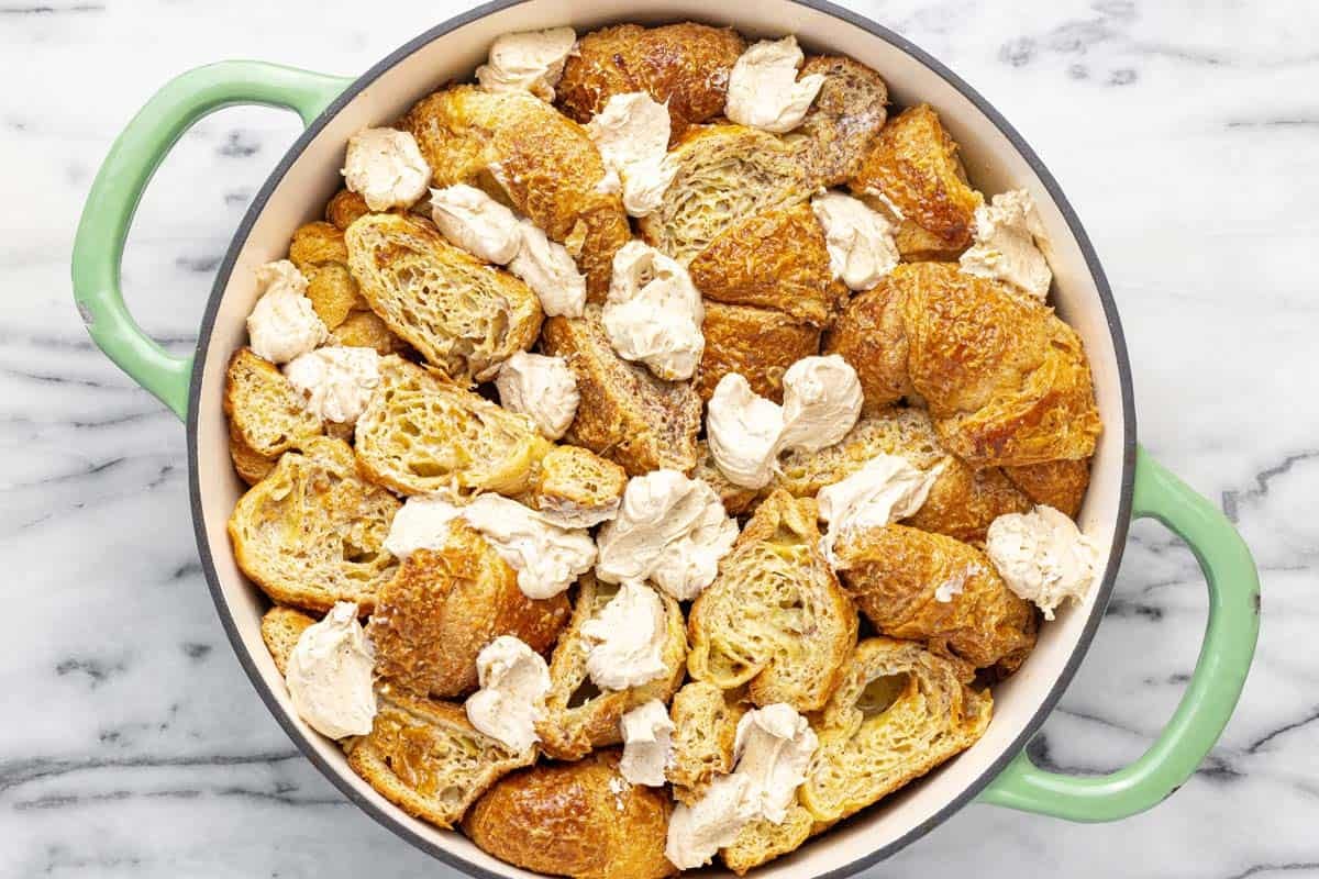 Brown sugar cream cheese dolloped on top of a croissant French toast bake.