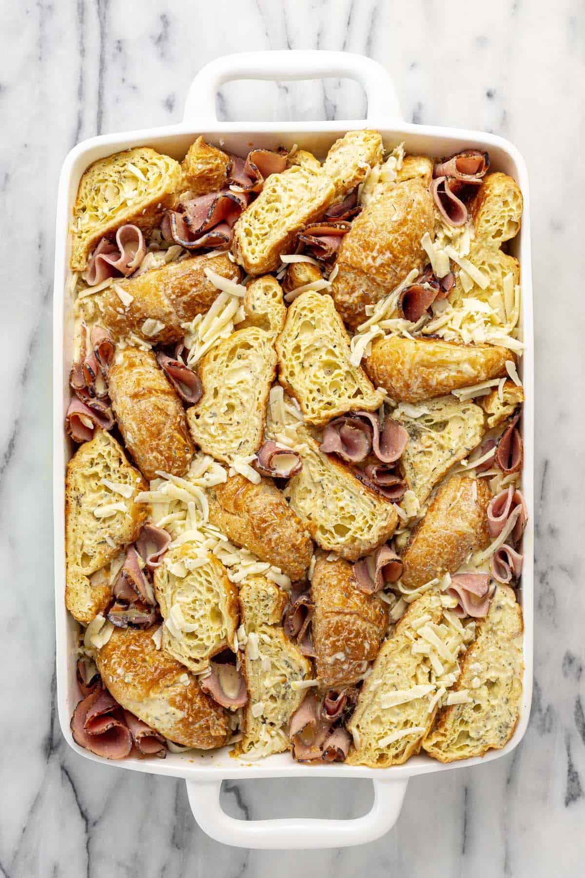 Large baking dish filled with a ham and cheese egg bake ready for the oven.