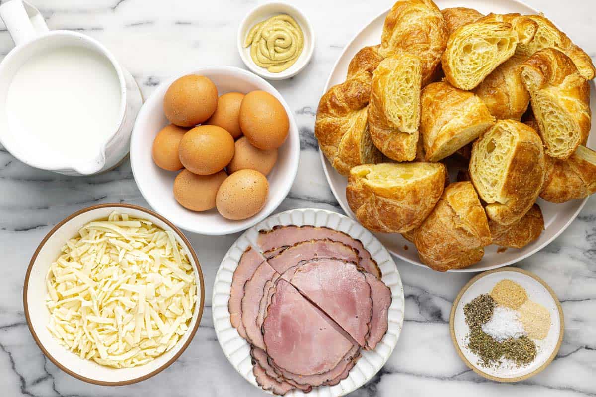 Bowls of ingredients to make ham and cheese croissant bake.